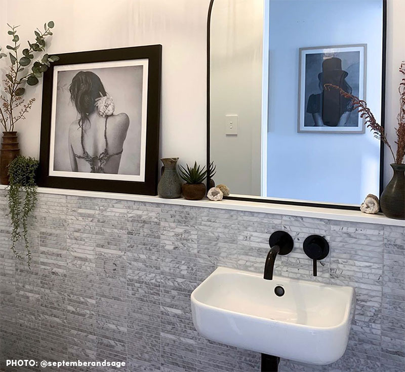 carrara marble tile bathroom with art photos and sink