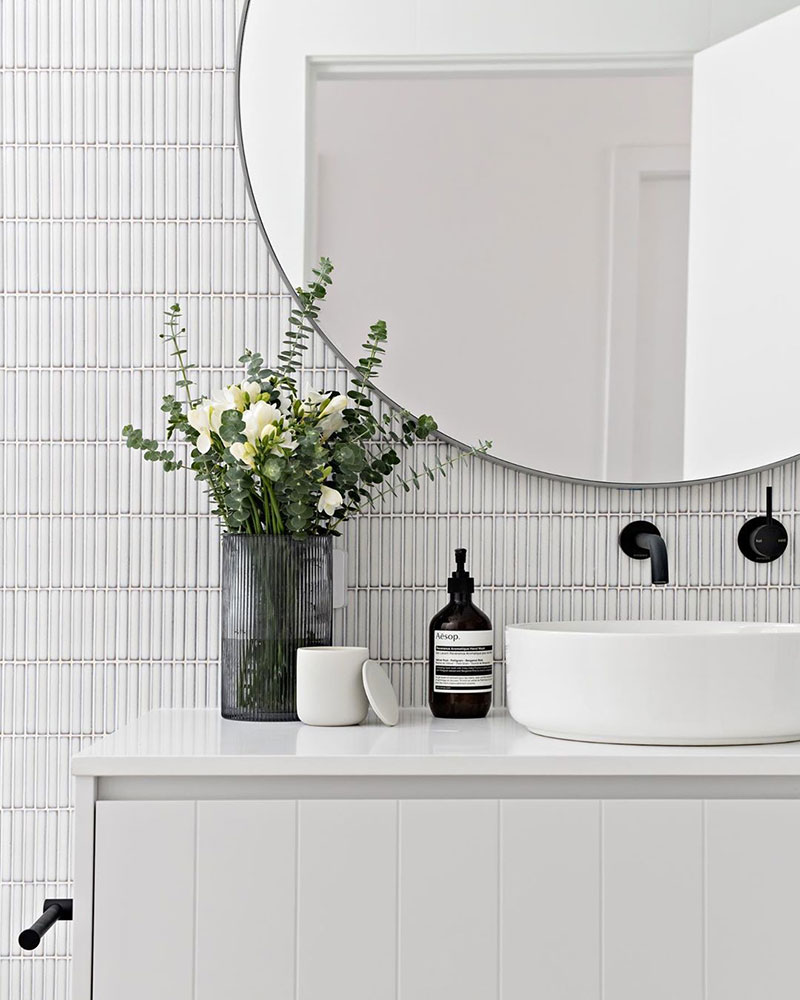 minimalist white bathroom with detailed white finger tiles